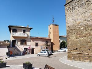 ein Gebäude mit einem Turm und Autos, die in einer Straße geparkt sind in der Unterkunft CASA BORGIA in Rignano Flaminio