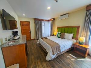 una habitación de hotel con una cama grande y una barra en Sibu Lodge, en Monteverde