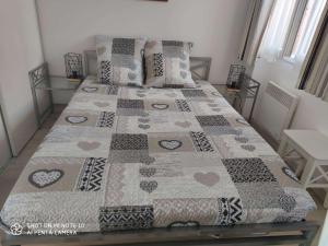 a bedroom with a bed with a quilt on it at Soulac Côté Plage vue ocean in Soulac-sur-Mer