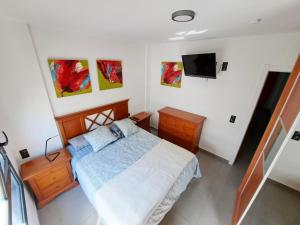 1 dormitorio con 1 cama y TV en la pared en Hub Retreat Las Palmas, en Las Palmas de Gran Canaria