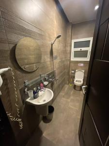 een badkamer met een wastafel, een spiegel en een toilet bij Solima pyramids inn in Caïro