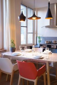 - une salle à manger avec une table, des chaises et des lumières dans l'établissement sejourcocooning, à Saint-Étienne