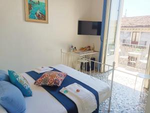 een slaapkamer met een bed en uitzicht op een balkon bij B&B Perla in Catania
