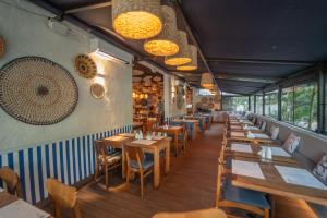 un restaurant avec des tables en bois, des chaises et des lumières dans l'établissement George V Alto De Pinheiros, à São Paulo