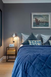 uma cama azul com um edredão azul e uma mesa em Steuerbord em Westerland