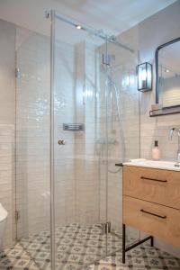 a bathroom with a glass shower with a sink at Steuerbord in Westerland