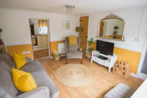 a living room with a couch and a tv at Hectors house in Ormesby Saint Michael