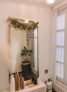 a mirror with a wreath on a wall in a room at Easel House in Seoul