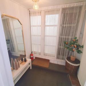 ソウルにあるEasel Houseの鏡、ソファ、窓が備わる客室です。