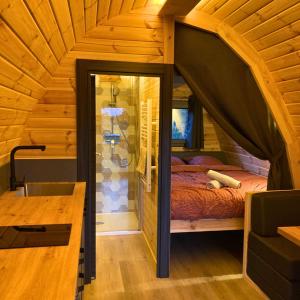 1 dormitorio en una casa en un árbol con 1 cama en Camping Sérendipité, en Neuvéglise