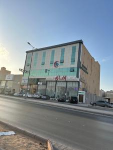 un gran edificio con coches aparcados frente a una calle en شقة مفروشة غرفتين بدخول ذاتي en Al Kharj