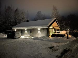 a house covered in snow with a car parked in front at Gudbrandsdalen view cabin in Strande