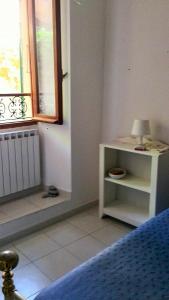 a bedroom with a bed and a window and a lamp at Chez Tamara with private parking and air conditioned in Monterosso al Mare