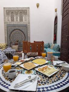 einen Tisch mit einem Tischtuch mit Essen drauf in der Unterkunft Riad Fes Colors & Spa in Fès