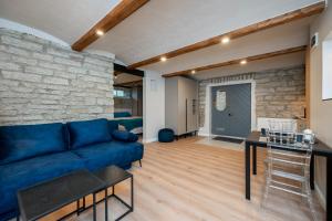 - un salon avec un canapé bleu et un mur en pierre dans l'établissement Kalamaja Apartment, à Tallinn