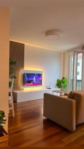 a living room with a couch and a tv on a wall at Apartamento av.Galicia playa in Finisterre