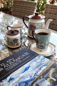 a table with two cups of coffee and a book at Bamba House Cusco in Cusco