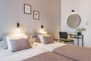 a bedroom with two beds and a table and a mirror at Ciel Comfort Living in Laganas