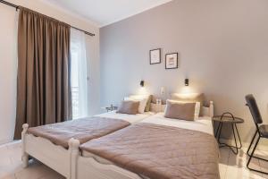 a bedroom with two beds and a window at Ciel Comfort Living in Laganas +8 photos