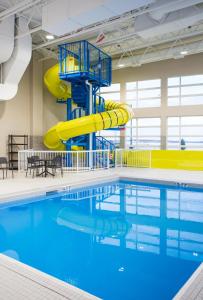 - une piscine avec toboggan dans un bâtiment dans l'établissement Holiday Inn Express & Suites Prince Albert - South, an IHG Hotel, à Prince Albert