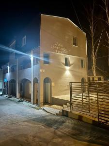 een gebouw met een hek er 's nachts voor bij Jokai Apartments Nr2,code entry in Sfântu-Gheorghe