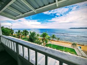 a balcony with a view of the beach and the ocean at Paunch Beach Retreat in Bocas Town
