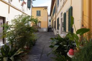 eine Gasse zwischen zwei Gebäuden mit Topfpflanzen in der Unterkunft La Casa di Emilia in Florenz