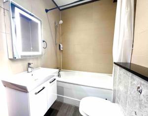 a bathroom with a sink and a toilet and a tub at 2 Bed- Camden Town in London