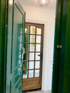 a green door in a room with a window at Neuilly's Finest in Neuilly-sur-Seine