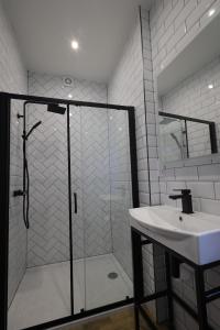 a bathroom with a glass shower and a sink at Red Lion Apartments in Spalding