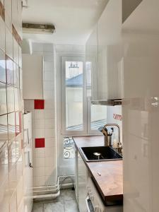 a small kitchen with a sink and a window at Neuilly's Finest in Neuilly-sur-Seine