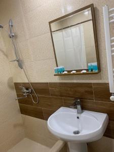ein Bad mit einem Waschbecken und einem Spiegel in der Unterkunft Villa Bodbe in Sighnaghi