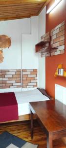 a room with a bed and a wooden table at Appartement LiHeRo in Antananarivo