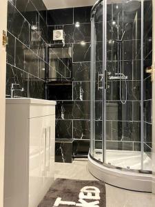 布拉姆霍普的住宿－Stonecroft，带淋浴和盥洗盆的黑色瓷砖浴室