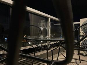 dos copas de vino sentadas en una mesa en un balcón en Comodidad y lujo! Con desayuno Incluido! G&A Rent en Ezeiza