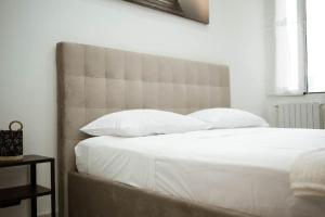 a bed with white sheets and pillows in a bedroom at Appartamento centrale vista mare Benny's apartment in Bari