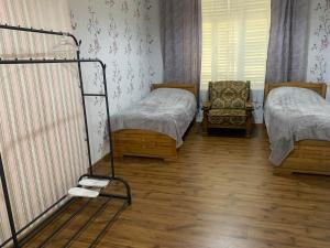 Cette chambre comprend deux lits et une chaise. dans l'établissement Villa Bodbe, à Sighnaghi