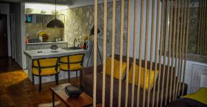une cuisine avec une table et un comptoir avec des chaises jaunes dans l'établissement Terminal Vidikovac, à Budva