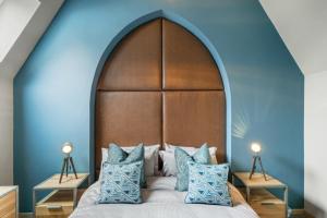 a bedroom with a large bed with blue walls at Towan House in Newquay