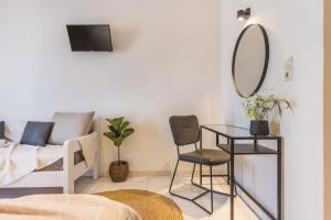 a living room with a mirror and a chair at Ciel Comfort Living in Laganas