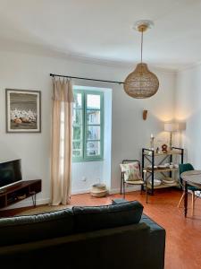 a living room with a couch and a window at L'écrin de Mona au coeur de Lourmarin in Lourmarin
