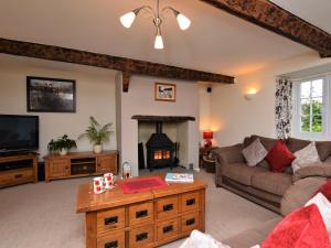 3 Bed in Lyme Regis BARRA في Winsham: غرفة معيشة مع أريكة ومدفأة