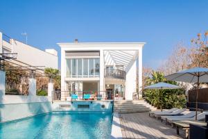 une maison avec une piscine en face d'une maison dans l'établissement Villa Cela, à El Masnou