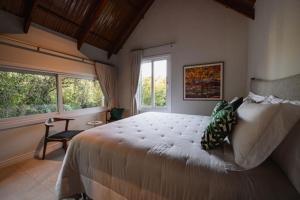 - une chambre avec un grand lit et une fenêtre dans l'établissement Vila Manaca Da Serra, à Canela