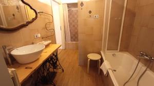 a bathroom with a sink and a tub and a mirror at Antico Chalet Momosa Maxi in Ovindoli