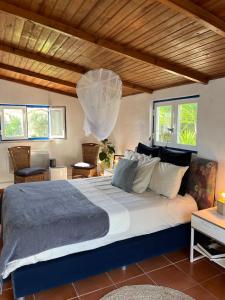 a bedroom with a large bed with a wooden ceiling at João Jungle in Açafora