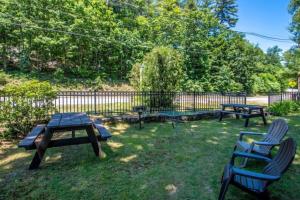 a picnic table and two chairs in a yard at Moose Manor- Squam Waterfront in Holderness