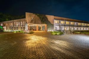 um grande edifício à noite com luzes acesas em Vert Hotel Penedo em Penedo