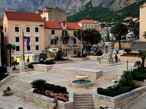 a town with a fountain in a courtyard with buildings at studio Fani in Makarska