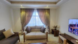 uma sala de estar com um sofá e uma janela em Madinaty apartment شقة فندقية مفروشة سوبر لوكس في مدينتي em Madinaty